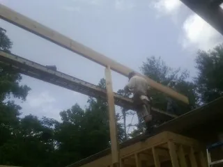 Carpenter setting a ridge beam over a new addition frame — Ice Dam Removal by Roofing Brothers in Washington Navy Yard